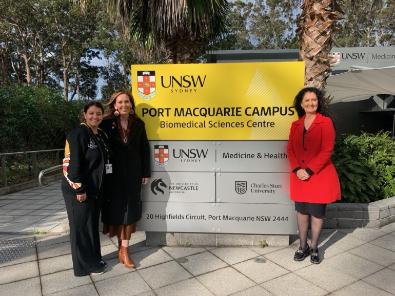 Photo of Leanne Holt and team in front of UNSW Port Macquarie campus sign